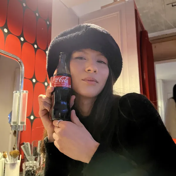 A model in a fur hat holding a glass Coca-Cola bottle at the Marilyn Monroe Foodmark event