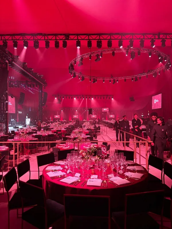 A grand red-lit dinner tent set for the EJAF Oscar Party
